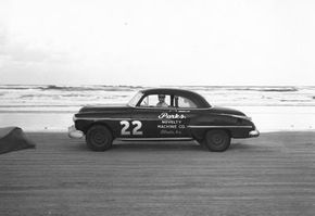 RacingOne/Getty Images Red Byron on Daytona Beach, Fla., in 1950. He won the first Strictly Stock race in 1949 in a similar Oldsmobile coupe. See more NASCAR images.