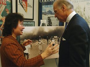 Kim Phuc, seen here with then-Sen. Joe Biden, stands in front of the famous photograph of herself as a child, being burned by napalm.