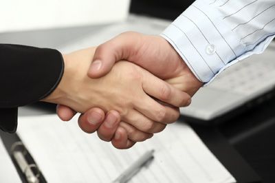 handshake over paperwork