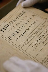 A very excited librarian holds a copy of one of the most important scientific works ever written, the Principia.