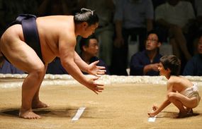 sumo wrestler and little boy in ring