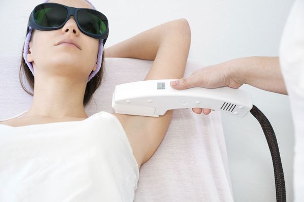 Young woman receiving laser epilation treatment