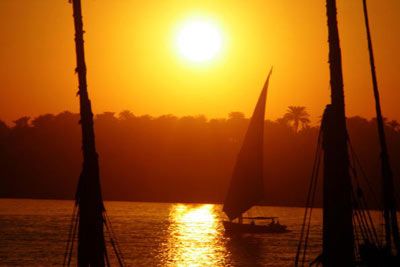Sailboat sailing alone in golden sunset.