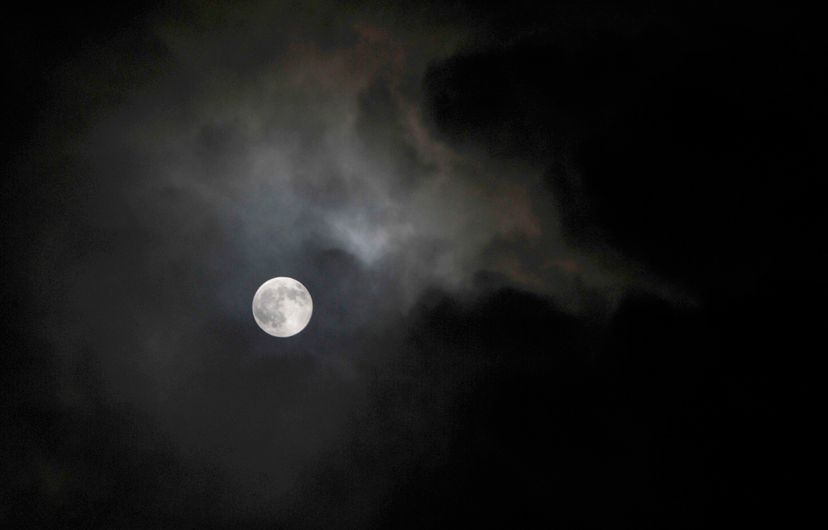The moon appears from behind clouds.