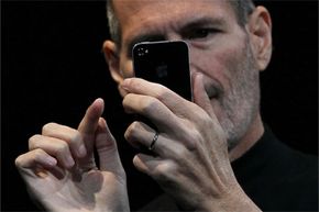 Steve Jobs looking at iPhone