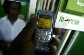 A man sends money through his phone using the M-PESA system.