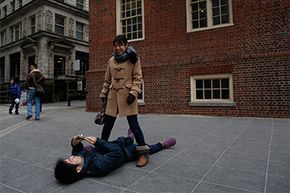 Hisashi Ueta, a Japanese student at Massachusetts General Hospital, lies down to get a better angle as he takes a picture of his wife. Foreign students like Ueta are exempt from certain taxes as they're considered nonresident aliens.