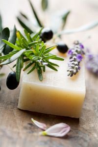bar of natural handmade soap, surrounded by fresh ingredients, (olive, rosemary, lavender)