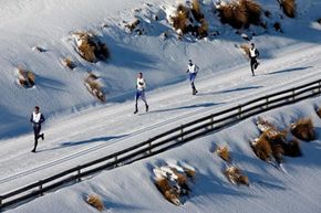 2009年在新西兰瓦纳卡举行的冬季铁人三项比赛中，冬季铁人三项运动员艰难地穿过雪地。＂width=