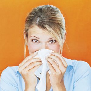 woman blowing nose with tissue