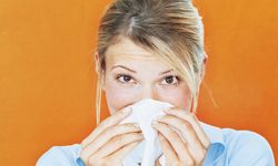 woman blowing nose with tissue