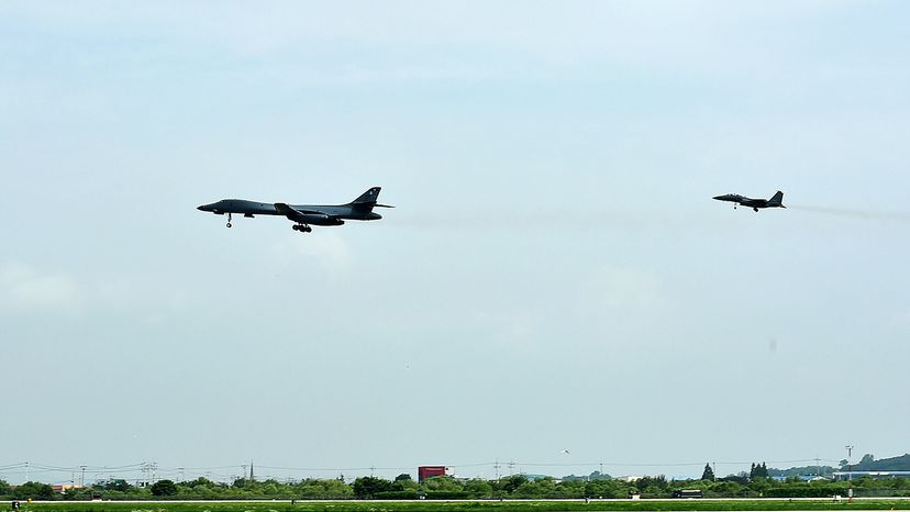 美国空军B-1B长矛兵轰炸机(左)与韩国的f - 15 k战斗机飞后朝鲜半岛北朝鲜的洲际弹道导弹测试7月30日,2017年。韩国国防部通过盖蒂图片社”border=