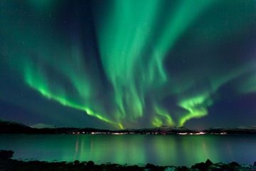 Mystical aurora polaris in arctic night sky.