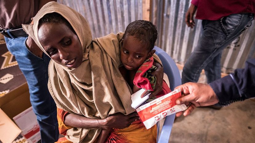 一位母亲和孩子在土耳其红新月会收到花生糊的Baydhabo营2017年3月在索马里的摩加迪沙附近。索马里陷入前所未有的和毁灭性的粮食危机威胁620万人,超过一半的人口。Maciej Moskwa / NurPhoto通过盖蒂图片社”width=