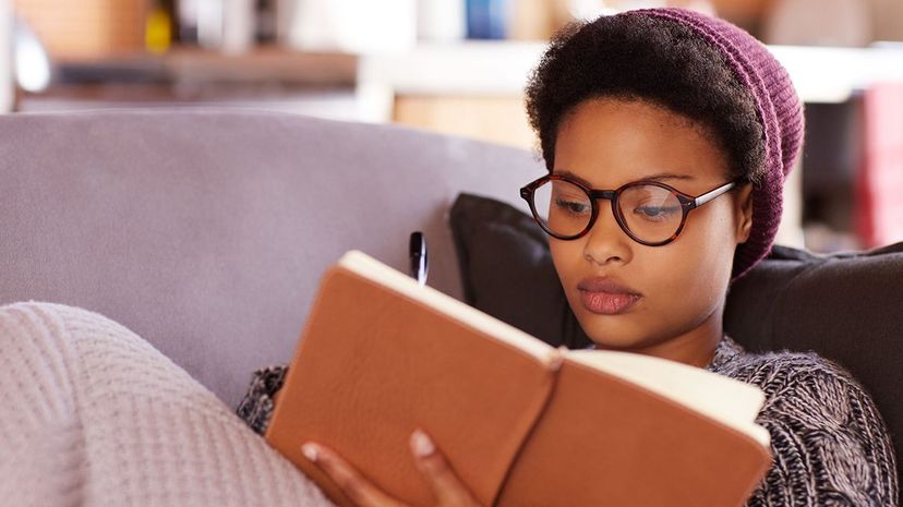 Bo reads alone on sofa indoors.