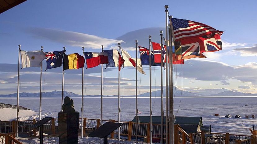 Flags of the original 12 signatory nations of the Antarctic Treaty fly next to a bust of Admiral Richard Byrd at McMurdo Station on October 21, 2005 in Antartica. Rob Jones/National Science Foundation via Getty images)