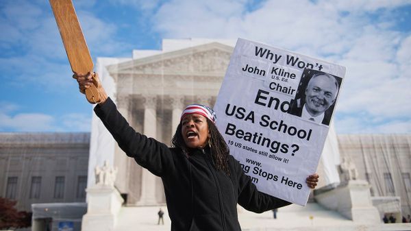 woman holding sign about corporal punishment bill outside the Supreme Court