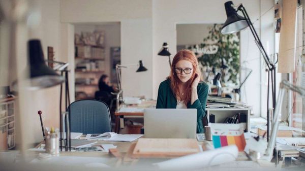 red haired woman working in ohome office