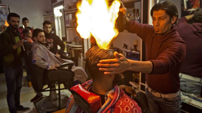 Palestinian barber Ramadan Edwan uses fire to straighten the hair of one of his clients. MAHMUD HAMS/AFP/Getty Images