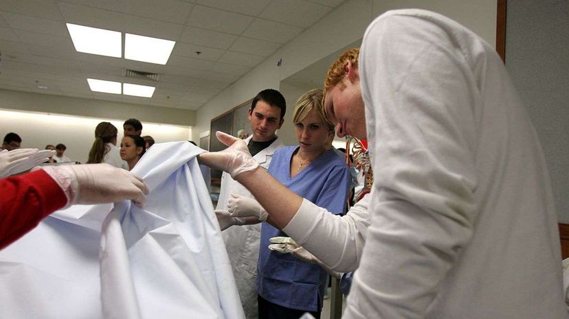 Medical students peek at their cadaver after a dedication and blessing ceremony honoring those who have donated their bodies for medical education at Loyola University's Stritch School of Medicine. Scott Strazzante/ Chicago Tribune/MCT via Getty Images