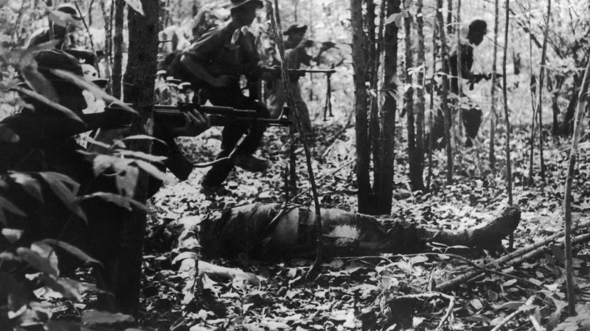 A Viet Cong detachment going into battle during the Vietnam War, January 1967. In the foreground is the body of a dead American soldier. Keystone/Hulton Archive/Getty Images