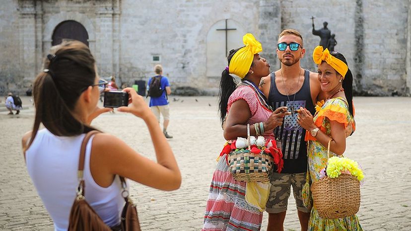 A U.S. tourist poses with women dressed in traditional clothing in the Old Town district of Havana, Cuba, in 2016. Yami Lage/AFP/Getty Images