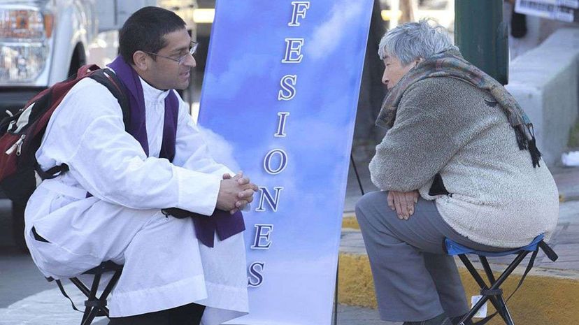 A priest takes confession to a woman before the return of Pope Francis to Mexico City on Feb. 13, 2016. DIANA ULLOA/AFP/Getty Images