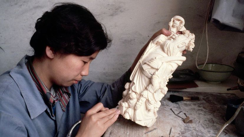 A Chinese woman creates a carving using elephant ivory. Dean Conger/Getty Images