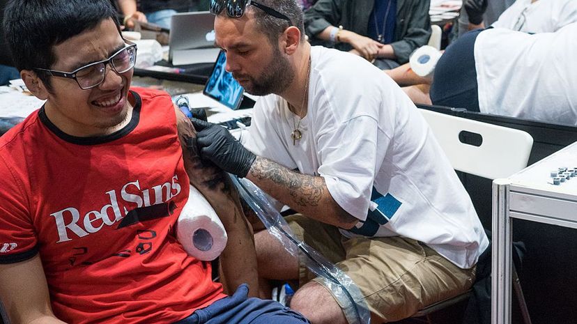 Getting and giving a tattoo both cause physical discomfort, as seen at the HK Tattoo Convention in Hong Kong. Yeung Kwan/Pacific Press/LightRocket via Getty Images