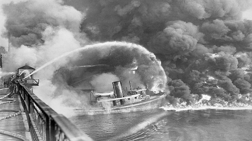 Firemen over the Cuyahoga River spray water on the tug Arizona while the river burns. Bettmann/Contributor/Getty