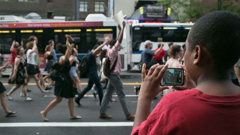 一个小男孩抓住了黑人的寿命问题抗议他的智能手机在7月7日,2016年。社会媒体,尤其是直播,起到了很大的作用在最近呼吁社会正义。卡拉安棚/ NurPhoto通过盖蒂图片社”width=
