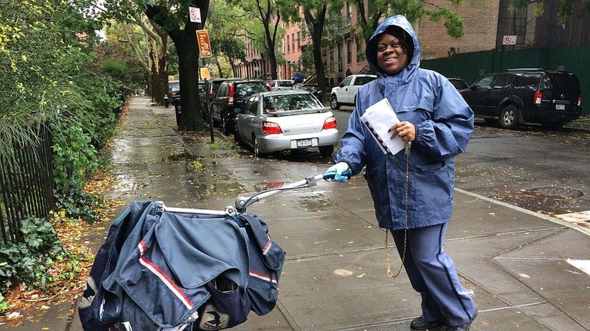 A letter carrier pushes her mail cart through Brooklyn on a rainy day. You know what they say: "Neither snow nor rain ..." Keith Getter/Getty Images