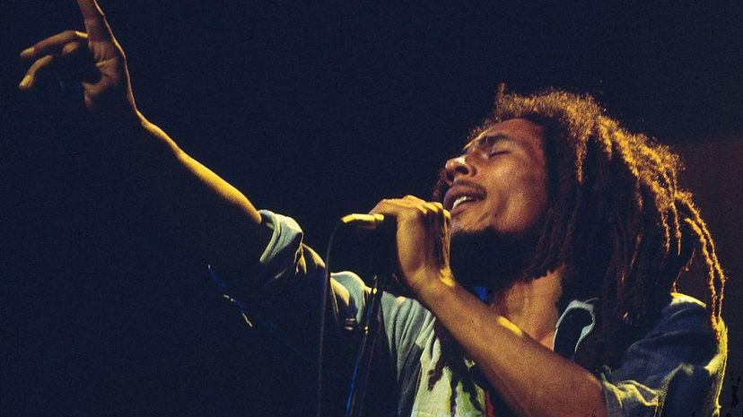 鲍勃·马利（Bob Marley）于1977年在英格兰的彩虹剧院现场表演。“width=