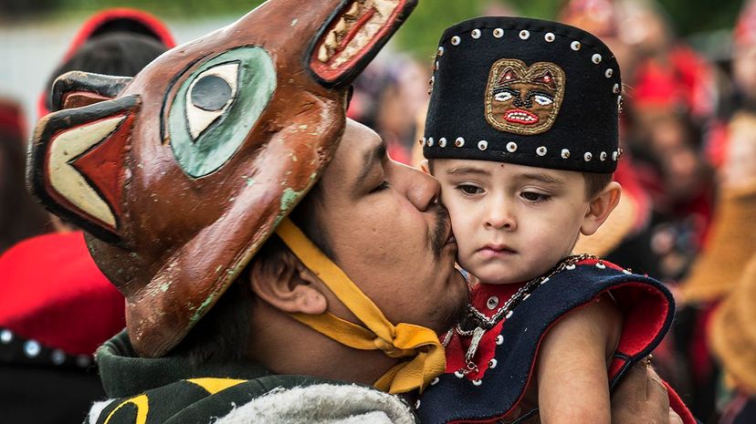 Tlingit tribe member J.J. Dewitt kisses his 2-year-old nephew Forrest Eide before they dance at the grand entrance of a 2014 Native American celebration in Juneau, Alaska. The Tlingit tribe has links to recently investigated archaeological sites. Linda Davidson/The Washington Post/Getty Images