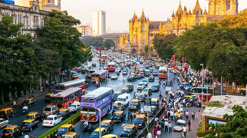 交通在印度孟买的Chhatrapati Shivaji Terminus火车站周围移动。彼得·亚当斯/盖蒂图像“width=