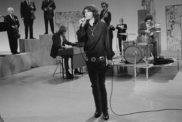 吉姆·莫里森（Jim Morrison）和其余的门（L-R Ray Manzarek，Robby Krieger和John Densmore）在1969年在“ Smothers Brothers Comedy Hour”上演出。“border=