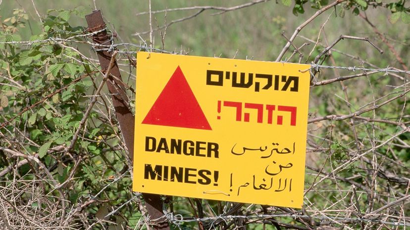 In the Golan Heights, a sign written in English, Hebrew, and Arabic warns of land mines. Richard T. Nowitz/Getty Images