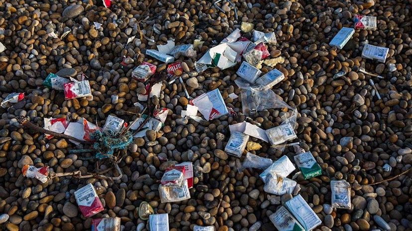 Cigarette packets from a container ship accident wash up on Chesil Beach in Dorset, England. : Andrew Aitchison/Getty Images