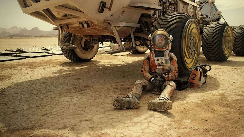 Matt Damon portrays Mark Watney in the film adaptation of 'The Martian.' In the film, he struggles to repair his spacesuit. Twentieth Century Fox