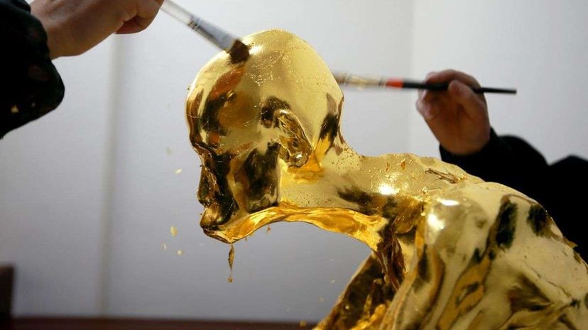 Workers apply gold leaf to the mummy of the Buddhist monk Fu Hou. Photoshot