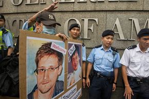 2013年6月，在一场支持爱德华·斯诺登(Edward Snowden)的示威活动中，香港警察在美国驻香港领事馆外站岗。＂border=