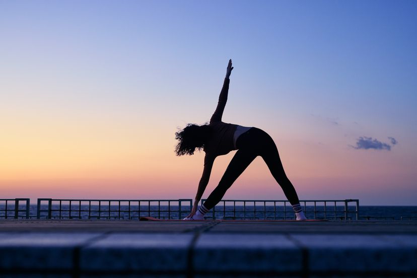 Women in their 20s in yoga pose with twisted triangles.