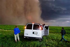 Tour guests dash back to the van as the changing sky takes a turn for the worse during a Tempest Tours storm chasing tour across the Great Plains of the U.S. in 2006.