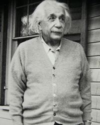 Black and white photo of Albert Einstein in a cardigan.