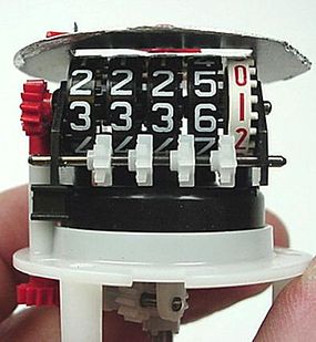 Each dial is then turned by pegs on the previous dial through a small helper gear (white).
