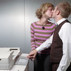 man and woman kissing at the copier