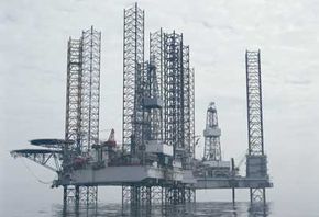 A jack-up rig can raise and lower itself on three or four massive "legs." Oil companies float these structures out to a drill site and then lower the legs until they touch the sea floor and elevate the rig out of the water.”border=