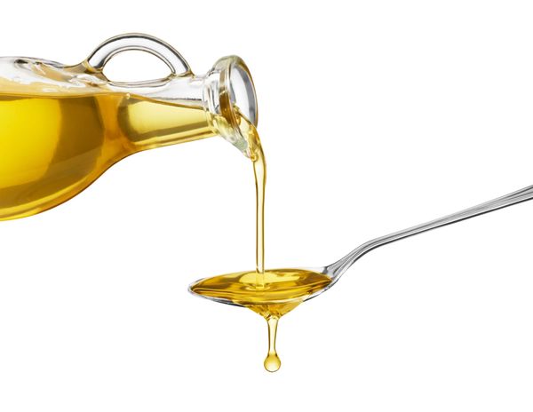 Olive oil being poured over a spoon