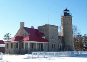 巨大的砖砌老Mackinac Point灯塔耸立着城堡般的墙壁和塔楼，是五大湖地区比较坚固和壮观的灯塔之一。查看更多灯塔图片。＂width=