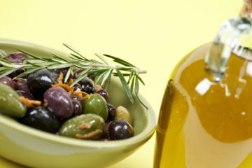 Olive oil next to dish of olives